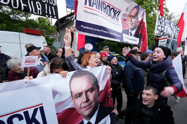 People carry placards in support of conservative presidential candidate Karol Nawrocki in Warsaw, Poland, Tuesday, May 13, 2025. (AP Photo/Czarek Sokolowski)