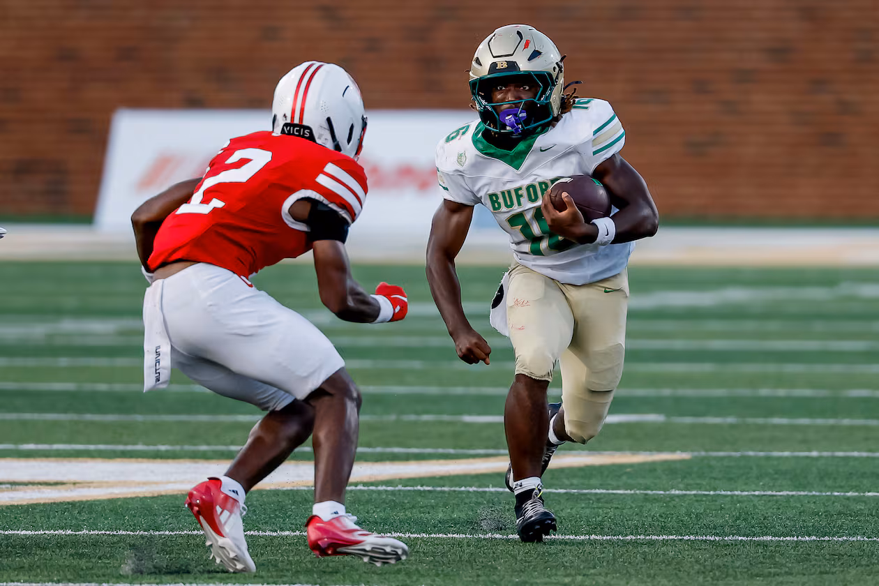 Buford's AJ Granville (right) runs while being defending by Gainesville's JaMarcus Sims during the second half Saturday, Aug. 22, 2026, in Buford. The Class 7A No. 1 Wolves beat the 6A No. 2 Red Elephants 39-19. (Erik S. Lesser for the AJC)
