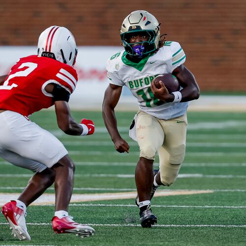 Buford's AJ Granville (right) runs while being defending by Gainesville's JaMarcus Sims during the second half Saturday, Aug. 22, 2026, in Buford. The Class 7A No. 1 Wolves beat the 6A No. 2 Red Elephants 39-19. (Erik S. Lesser for the AJC)