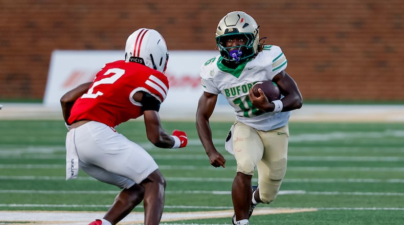 Buford's AJ Granville (right) runs while being defending by Gainesville's JaMarcus Sims during the second half Saturday, Aug. 22, 2026, in Buford. The Class 7A No. 1 Wolves beat the 6A No. 2 Red Elephants 39-19. (Erik S. Lesser for the AJC)