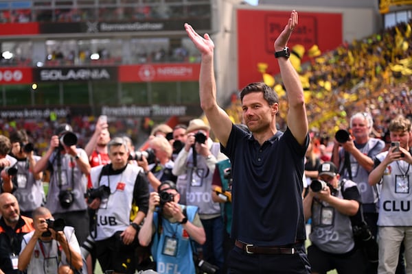 Leverkusen's head coach Xabi Alonso waves to the fans before the German Bundesliga soccer match between Bayer 04 Leverkusen and Borussia Dortmund in Leverkusen, Germany, Sunday, May 11, 2025. (Marius Becker/dpa via AP)