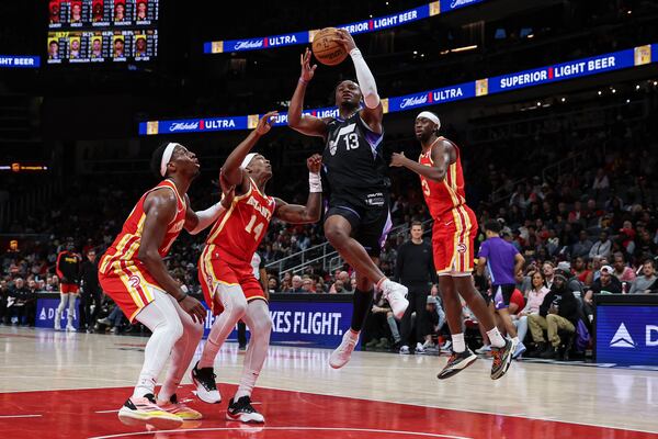 Utah Jazz guard Isaiah Collier (13) drives to the basket against Atlanta Hawks guard Terance Mann (14), forward Onyeka Okongwu, left, and guard Caris LeVert (3) during the second half of an NBA basketball game, Sunday, April 6, 2025, in Atlanta. (AP Photo/Colin Hubbard)