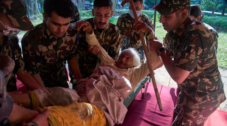 An elderly survivor is taken to a makeshift hospital for treatment at the army's Maithali barracks after being rescued from flash flooding in Nuwakot district, Nepal, Thursday, Aug. 27, 2026. (AP Photo/Niranjan Shrestha)