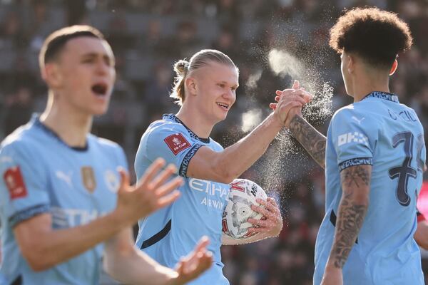 Manchester City's Erling Haaland, center, celebrates with Manchester City's Nico O'Reilly, right, after scoring his side's opening goal during the English FA Cup quarterfinal soccer match between Bournemouth and Manchester City at the Vitality stadium in Bournemouth, England, Sunday, March 30, 2025. (AP Photo/Ian Walton)