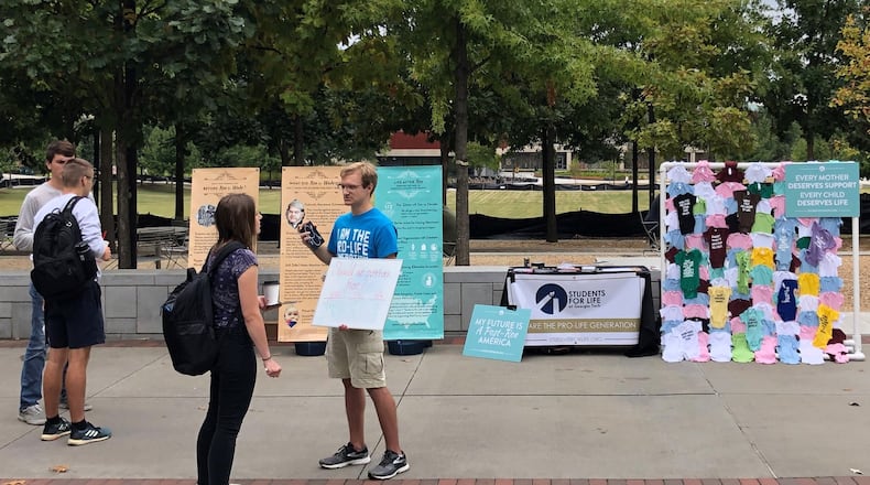 Students for Life President Brian Cochran discusses landmark abortion case Roe v. Wade with a fellow Georgia Tech student during a campus information event on Tech Walkway. CONTRIBUTED