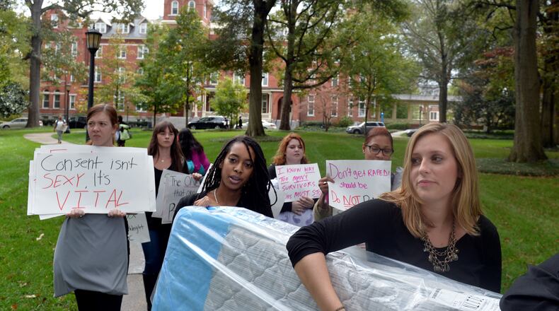 Agnes Scott College student Grace Starling, right, and fellow students carry a mattress around campus to show support for sexual assault victims as part of a national day of action, Carry That Weight Wednesday October 29, 2014. Some students carried mattresses to class with them in support of Columbia University student Emma Sulkowicz, who has carried a mattress around campus in protest after she alleged a male student raped her. BRANT SANDERLIN / BSANDERLIN@AJC.COM