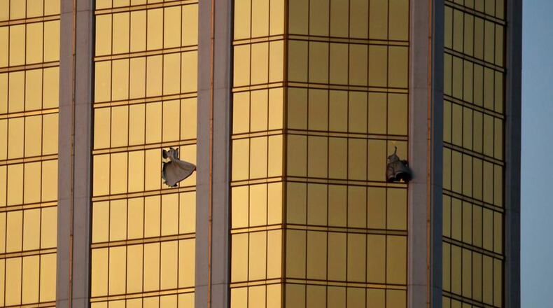 Drapes billow out of broken windows at the Mandalay Bay resort and casino Monday, Oct. 2, 2017, on the Las Vegas Strip following a deadly shooting at a music festival in Las Vegas. A gunman was found dead inside a hotel room. (AP Photo/John Locher)