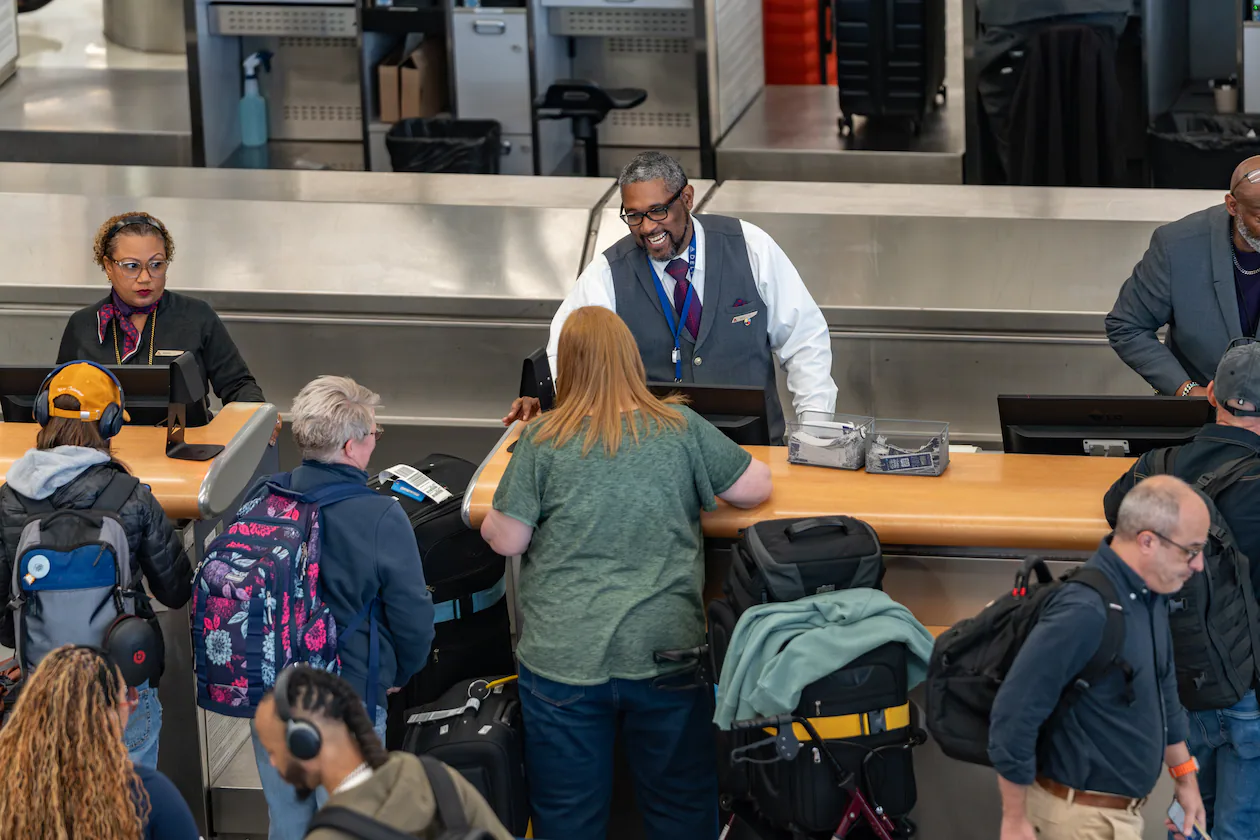 Delta employees process checked bags at Hartsfield-Jackson Atlanta International Airport. Unless you have certain perks, that bag will cost you more to get it on the plane. (Ben Hendren for the AJC)
