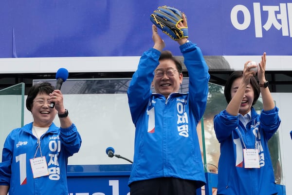 South Korea's Democratic Party's presidential candidate Lee Jae-myung, center, reacts after hurling a baseball ball during a presidential election campaign at Jamsil Sports Complex in Seoul, South Korea, Thursday, May 29, 2025. (AP Photo/Ahn Young-joon)