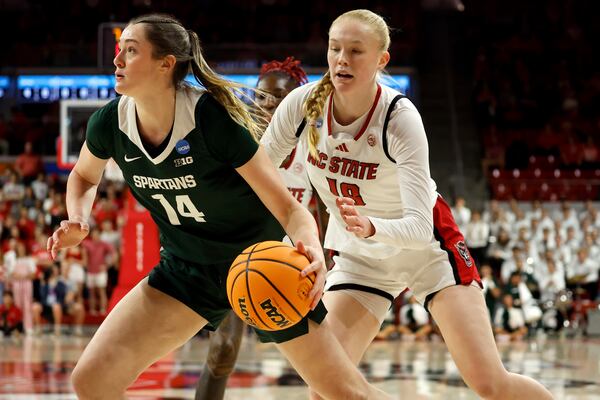 Michigan State's Grace VanSlooten (14) protects the ball from North Carolina State's Tilda Trygger (18) during the first half in the second round of the NCAA college basketball tournament in Raleigh, N.C., Monday, March 24, 2025. (AP Photo/Karl DeBlaker)