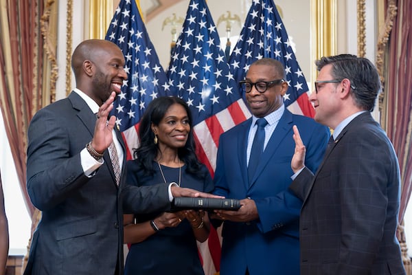 New U.S. Rep. Everton Blair (from left), D-Ga., joined by his mother, Fiona Blair, and father, Everton Blair Sr., stands for a swearing-in ceremony with Speaker of the House Mike Johnson, R-La., at the Capitol in Washington on Tuesday. (J. Scott Applewhite/AP)
