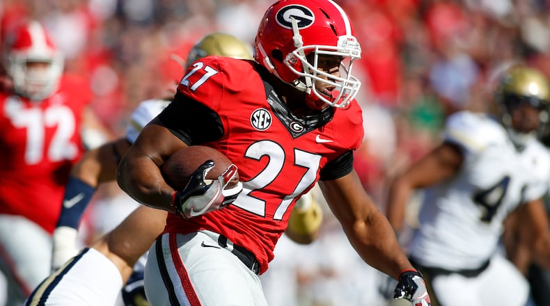 Georgia running back Nick Chubb (27) runs the ball against Georgia Tech in the first half of an NCAA college football game in Athens, Ga. Now that they've decided to put potential pro careers on hold, Chubb and fellow running back Sony Michel want to cap their junior seasons with a win in the Liberty Bowl and set by the tone for a big 2017 campaign. (AP Photo/Brett Davis, File)