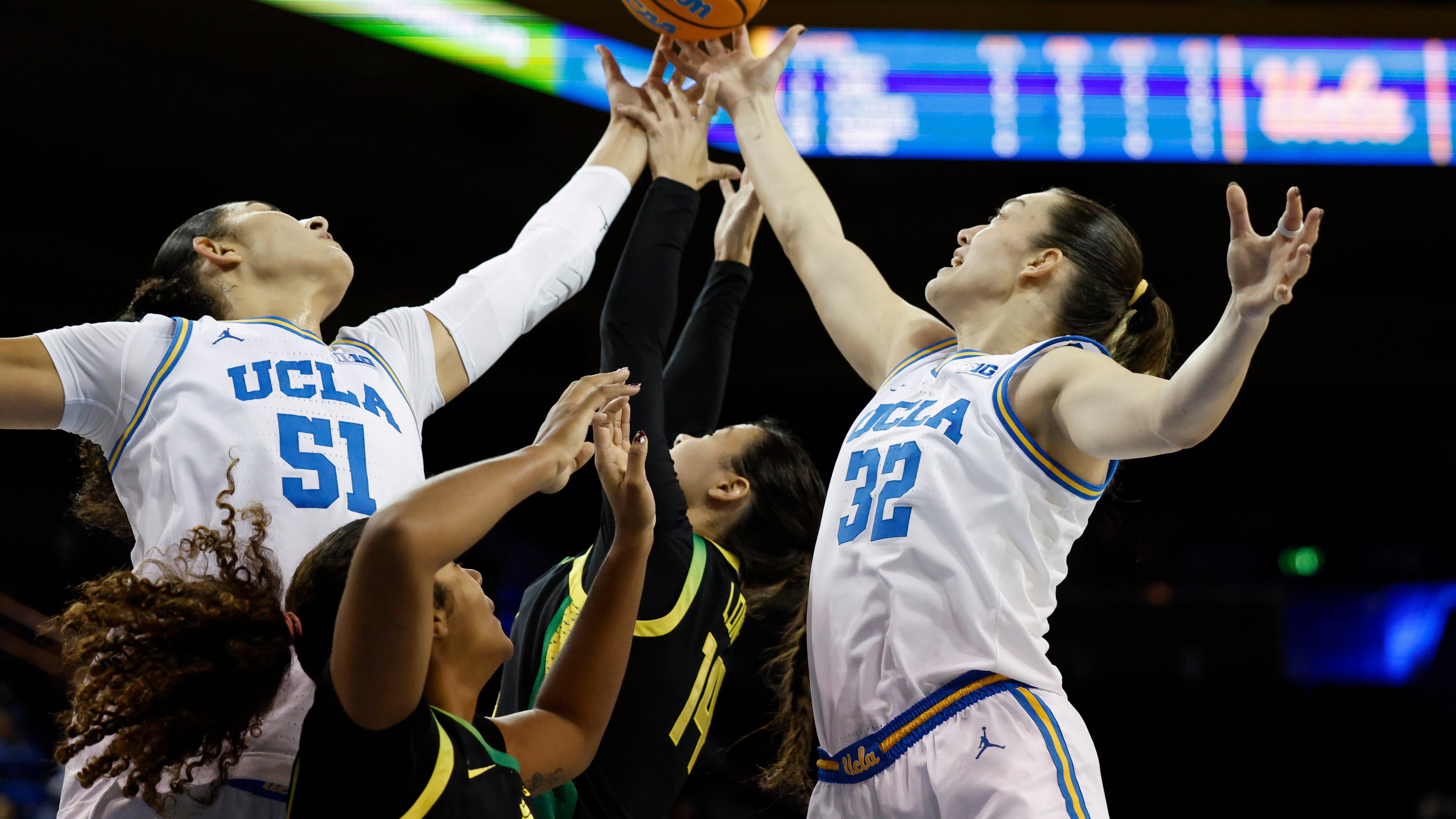 UCLA center Lauren Betts (51), Oregon forward Ehis Etute, second from left, Oregon guard Ari Long (14) and Oregon forward Angela Dugalić (32) reach for the ball during the first half of an NCAA college basketball game Sunday, Dec. 7, 2025, in Los Angeles. (AP Photo/Caroline Brehman)