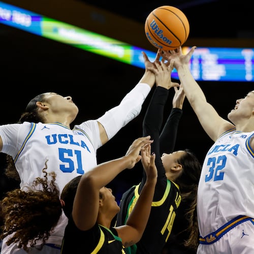 UCLA center Lauren Betts (51), Oregon forward Ehis Etute, second from left, Oregon guard Ari Long (14) and Oregon forward Angela Dugalić (32) reach for the ball during the first half of an NCAA college basketball game Sunday, Dec. 7, 2025, in Los Angeles. (AP Photo/Caroline Brehman)