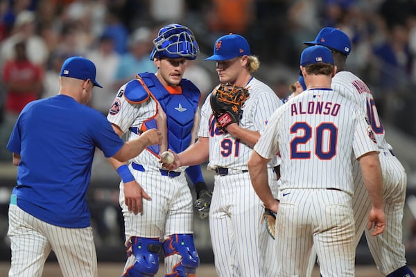 New York Mets pitcher Jonathan Pintaro, center, hands the ball to manager Carlos Mendoza as he leaves during the ninth inning of a baseball game against the Atlanta Braves Wednesday, June 25, 2025, in New York. (AP Photo/Frank Franklin II)