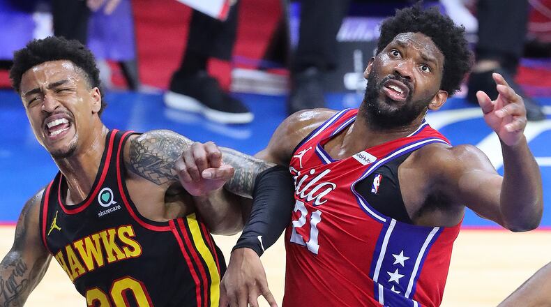 Hawks forward John Collins and Sixers center Joel Embiid battle for a rebound under the basket during Sunday's Eastern Conference semifinal matchup in Philadelphia.