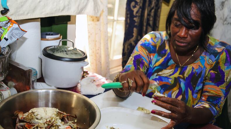 With practiced hands, chef and author Sallie Ann Robinson swiftly picks the sweet, tender crab meat from the legs and shells, showcasing her expertise and the efficiency honed by generations of island cooking in a photo from 2024. (Adriana Iris Boatwright for The Atlanta Journal-Constitution)