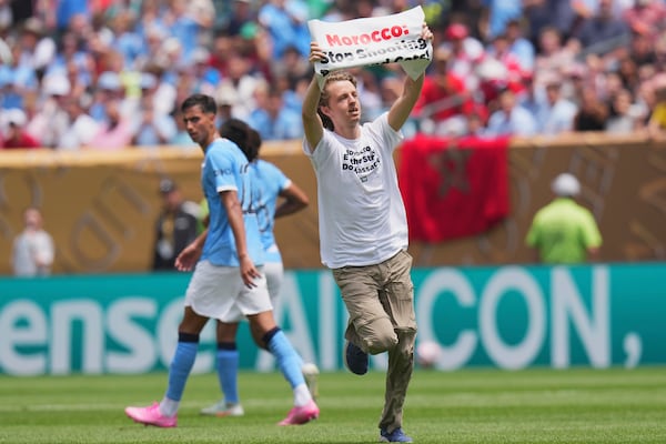 A protester runs on the field during the Club World Cup group G soccer match between Manchester City and Wydad AC in Philadelphia, Wednesday, June 18, 2025. (AP Photo/Chris Szagola)