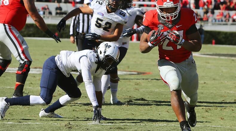 Georgia tailback Nick Chubb gets past Charleston Southern defenders for his second touchdown run of the first half for a 31-0 lead in a college football game on Saturday, Nov. 22, 2014, in Athens. CURTIS COMPTON / CCOMPTON@AJC.COM