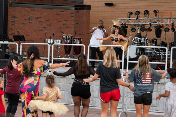 Dawn Mahealani Douglas, owner of Mahealani’s Polynesian Entertainment, demonstrates Polynesian dance moves as audience members follow along in Lawrenceville, Ga. September 9, 2022. Douglas said that in Polynesia, performers let people watch their dances before inviting them to join in. (Kendra A. Ransum/Fresh Take Georgia)