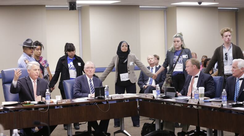 More than two dozen student activists and faith leaders on Wednesday demonstrated against Georgia Board of Regents policies that bar immigrants without legal status from attending five of the state’s top universities and paying in-state tuition at its others. One student was arrested. BOB ANDRES / BANDRES@AJC.COM