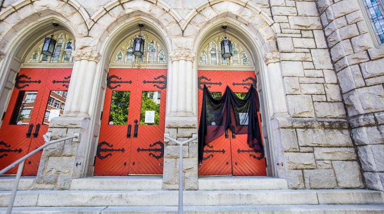 Saint Mark United Methodist Church on Peachtree Street has veiled one front door in respect of Good Friday on April 10, 2020. The veil also covers one of the posted messages that the church is closed until further notice. JENNI GIRTMAN / FOR THE AJC