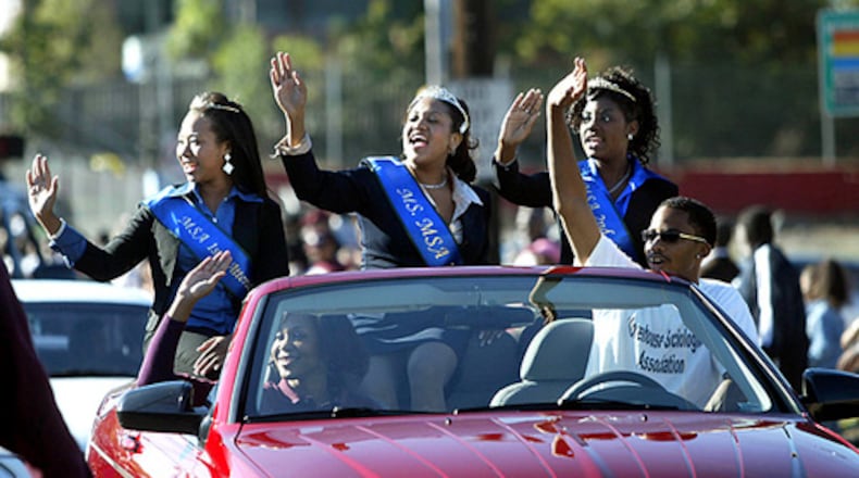 Members of the Morehouse College Sociological Association wave to spectators as they drive down Joseph E. Lowery Boulevard during the Morehouse Homecoming Parade. (From left) Melanie Harris, first attendant, Gimel Rogers, queen, and Qivon Annan, second attendant enjoy the college's homecoming. (Jason Getz/AJC FILE)