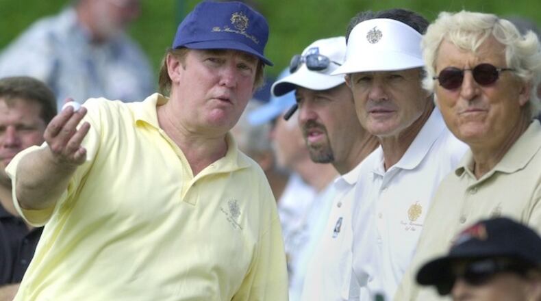 FILE - In this Nov. 20, 2002, file photo, Donald Trump, left, talks about the condition of his golf course with a group of spectators on the 15th tee during the LPGA Tour Championship Pro Am round at the Trump International Golf Club in West Palm Beach, Fla. Donald Trump was a distraction at golf tournaments even before he was running for president. (AP Photo/Marta Lavandier, File)