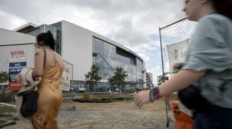 A group of high school seniors with the National Beta Club make their way past a construction entrance from the parking lot, Tuesday, June 18, 2024, in Savannah, Georgia. The Beta Club convention is host to more than 22,000 students across grades 4-12. (AJC Photo/Stephen B. Morton)