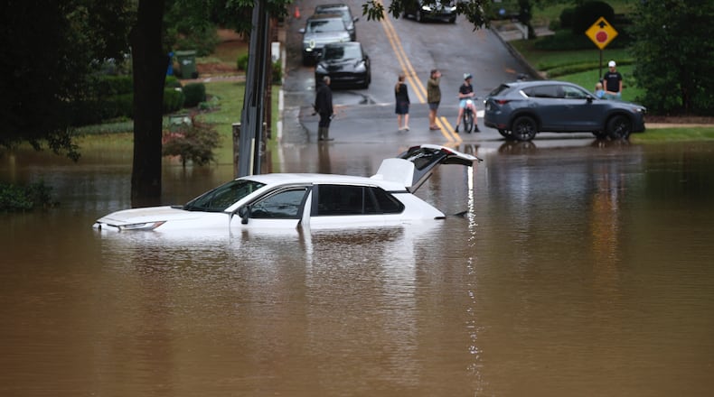 Flood waters from Hurricane Helene trap cars at Sagamore Drive near Northside in Atlanta on Friday, Sept. 27, 2024. (Ben Gray for the AJC)