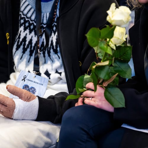 A victim with burned hands and relatives attend the official commemorative ceremony for the victims of the deadly fire at the "Le Constellation" bar in Crans-Montana, in Martigny, Switzerland, Friday, Jan. 9, 2026. (Laurent Gillieron/Keystone/Pool via AP)