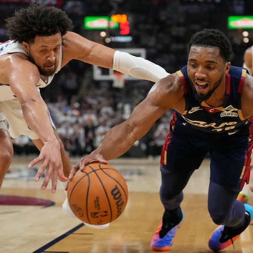 Detroit Pistons' Cade Cunningham, left, and Cleveland Cavaliers' Donovan Mitchell, right, reach for the ball in the first half of Game 4 of a second-round NBA basketball playoff series Monday, May 11, 2026, in Cleveland. (AP Photo/Sue Ogrocki)