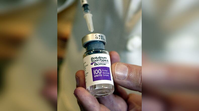 A doctor holds a bottle of Botox, which eliminates wrinkles by weakening or paralyzing the facial muscles. Texas authorities are trying to find a woman who broke into a Botox clinic Friday and made off with an armful of anti-aging products. Don Murray/Getty Images