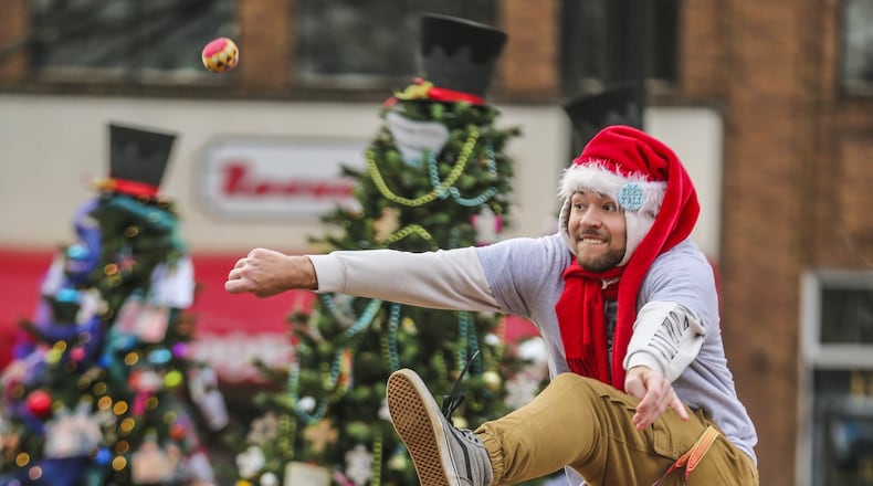Ben Snowden, 19, one of Santa’s helpers at the Santa on the Square in Marietta, kept warm by playing hacky sack on Dec. 19, 2018. JOHN SPINK/AJC