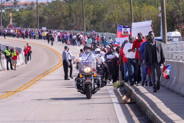 Haitian community members show up in large numbers at the Southern Blvd. bridge in West Palm Beach Monday, January 15, 2018 to protest recent remarks made by President Donald Trump against Haiti. The group said they were there to demand an apology from the President.  Damon Higgins / The Palm Beach Post