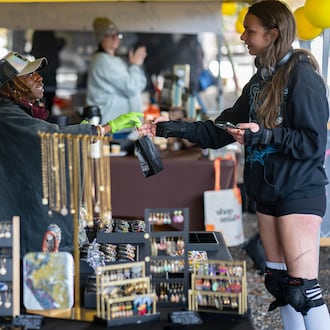 Christina Mondestin (left) owner of Beni Destiné jewelry, sells a necklace at her booth at the Atlanta Beltline Marketplace's annual Small Business Saturday event on Nov. 29, 2025. (Ben Hendren for the AJC)