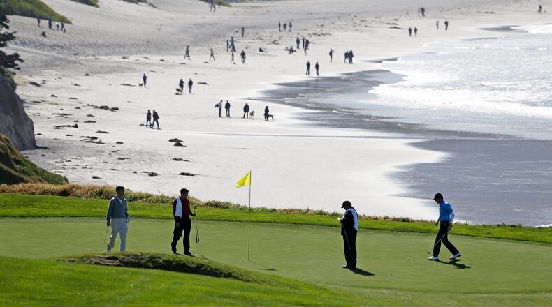 FILE - In this Feb. 6, 2013, file photo, Roberto Castro, right, walks to his ball on the tenth green of the Pebble Beach Golf Links during a practice round of the AT&T Pebble Beach Pro-Am golf tournament in Pebble Beach, Calif. It's played on one of the world's most picturesque courses on the first weekend after the Super Bowl, offering magnificent views of the Monterey Peninsula to golf fans still digging out from the snow. (AP Photo/Eric Risberg, File)