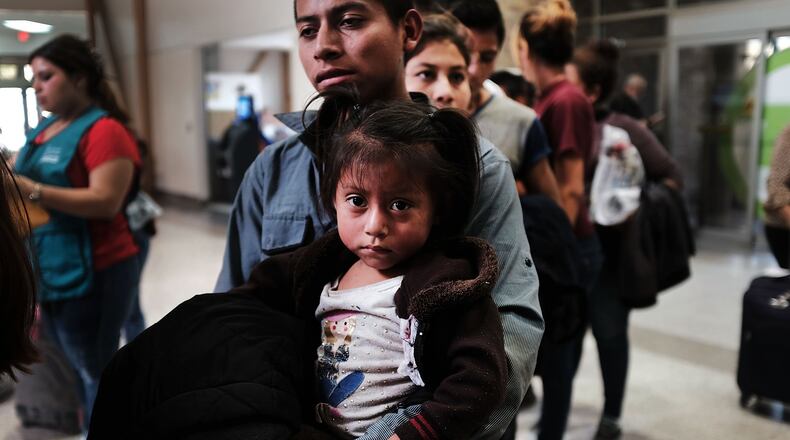 A Guatemalan father and his daughter arrive with dozens of other women, men and their children at a bus station following release from U.S. Customs and Border Protection on June 23, 2018, in McAllen, Texas. (Photo by Spencer Platt/Getty Images)