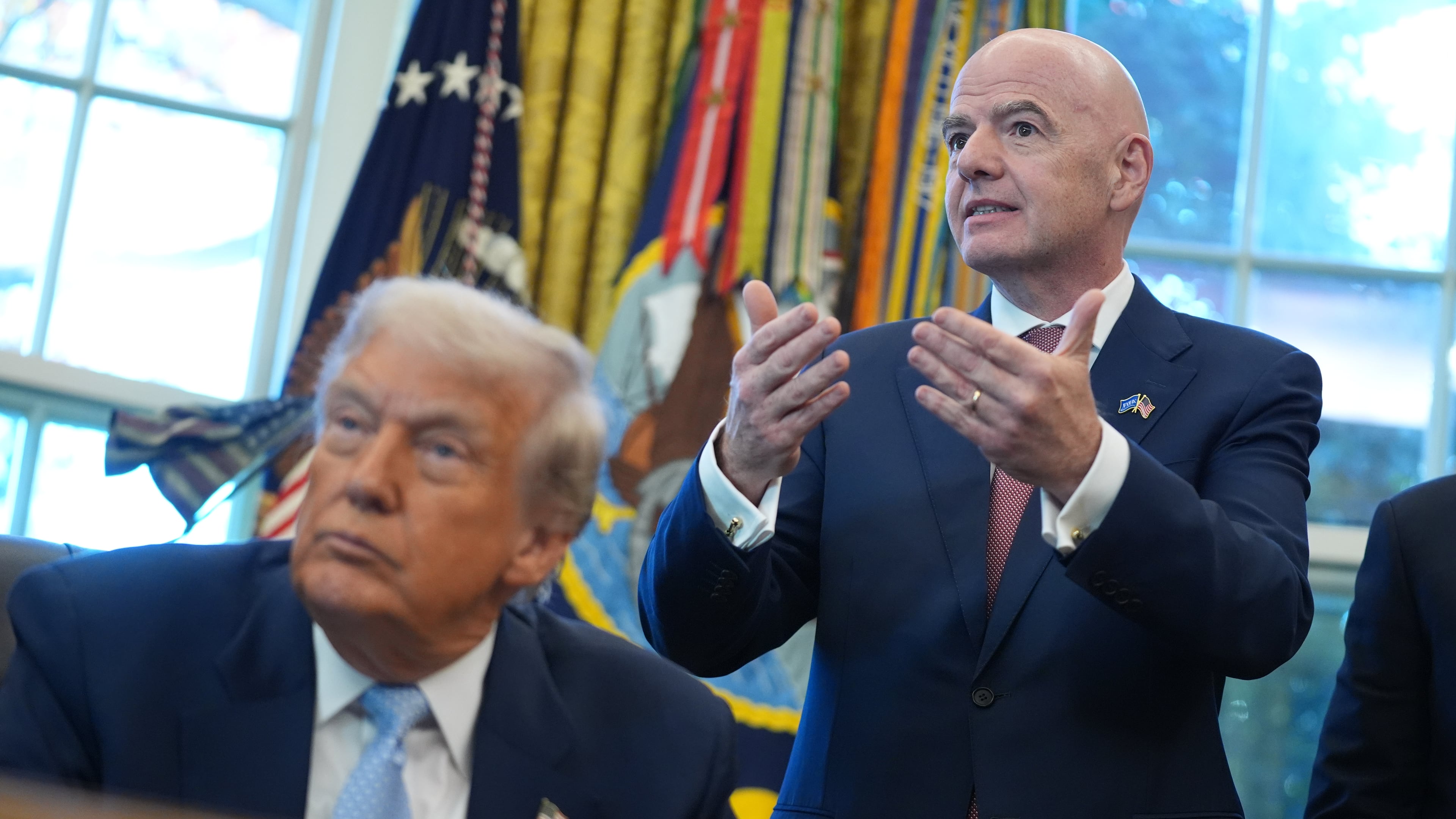 FILE - President Donald Trump listens as FIFA President Gianni Infantino speaks during a meeting with the White House task force on the 2026 FIFA World Cup in the Oval Office of the White House, Nov. 17, 2025, in Washington. (AP Photo/Evan Vucci, File)