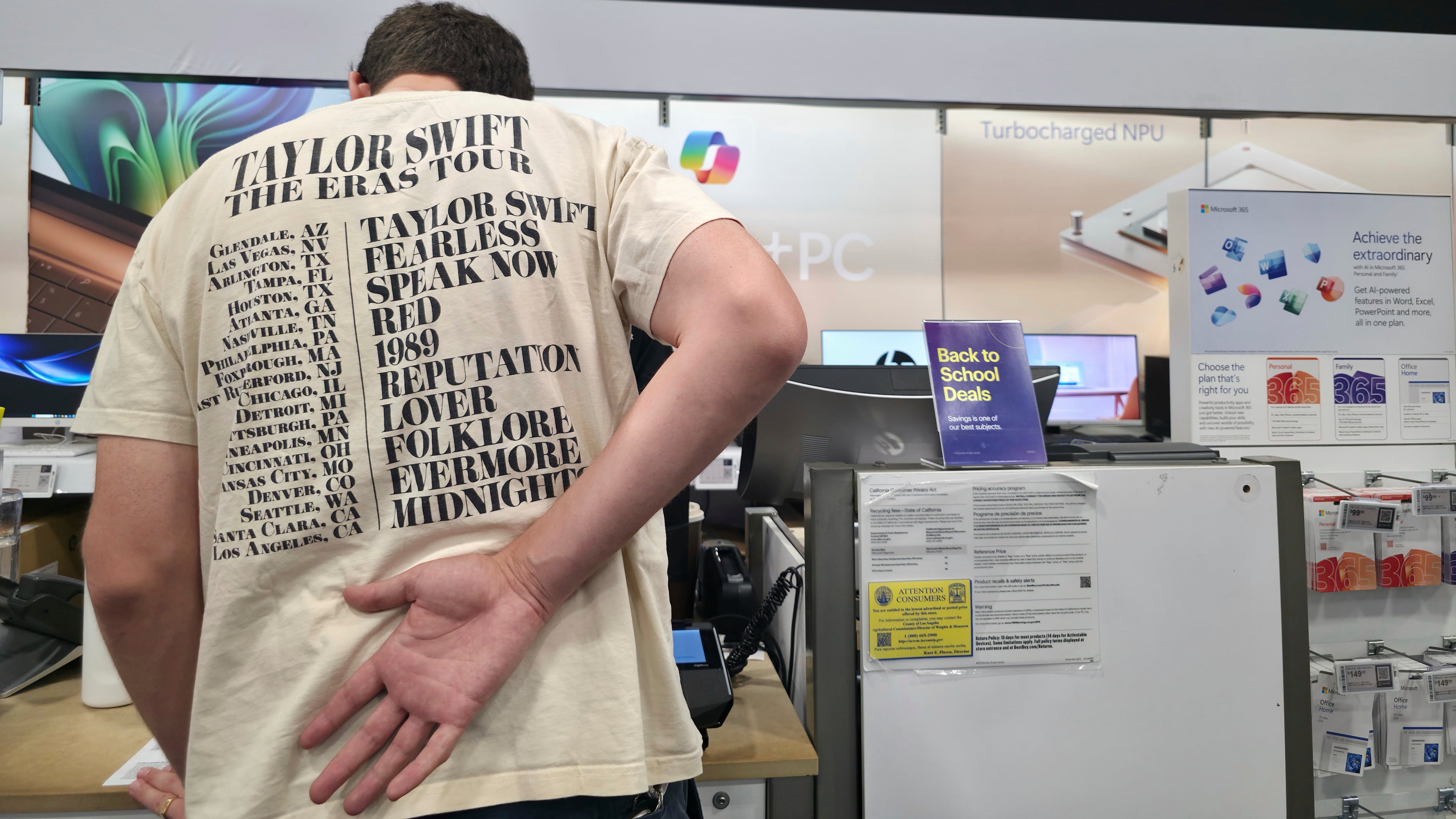FILE - Middle school teacher Jeremy Hook shops for the latests Microsoft's Surface Laptop Copilot+ PC's at Best Buy Atwater Village store in Glendale, Calif., Tuesday, July 29, 2025. (AP Photo/Damian Dovarganes, File)