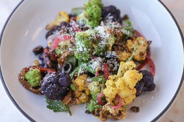 A bowl of roasted cauliflower florets, tossed with arugula, roasted red and yellow peppers, pickled onions, fried capers and black olives, is on the menu at Baraonda Ristorante & Bar. Natrice Miller/natrice.miller@ajc.com