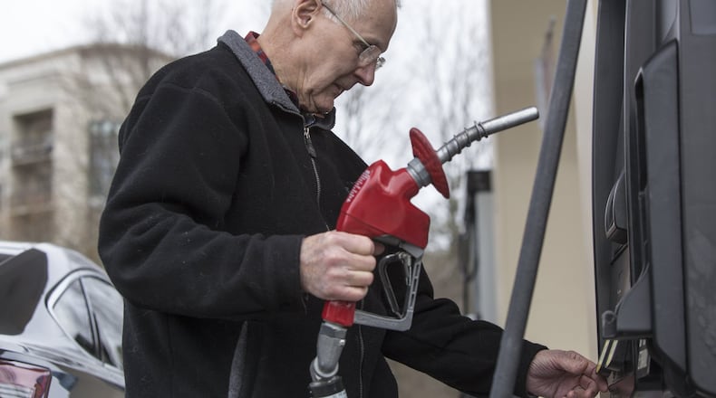 Atlanta drivers are paying more at the pump and prices are likely to rise through through the spring. Here, Harry Haake is about to fill up recently at a Costco gas station in Atlanta. (CASEY SYKES, CASEY.SYKES@AJC.COM)