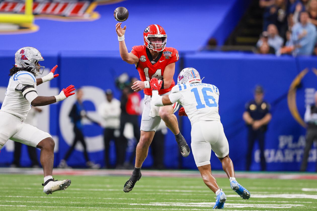 Georgia quarterback Gunner Stockton (center) faces pressure from Ole Miss safety Wydett Williams Jr. (right) during the Sugar Bowl at the Caesars Superdome on Thursday, Jan. 1, 2026, in New Orleans. The Rebels beat the Bulldogs, 39-34. (Jason Getz/AJC)