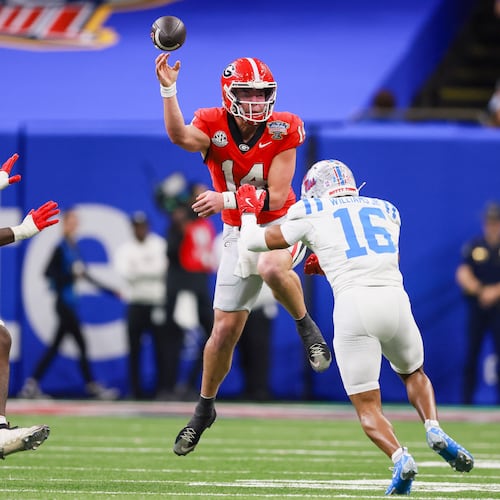 Georgia quarterback Gunner Stockton (center) faces pressure from Ole Miss safety Wydett Williams Jr. (right) during the Sugar Bowl at the Caesars Superdome on Thursday, Jan. 1, 2026, in New Orleans. The Rebels beat the Bulldogs, 39-34. (Jason Getz/AJC)
