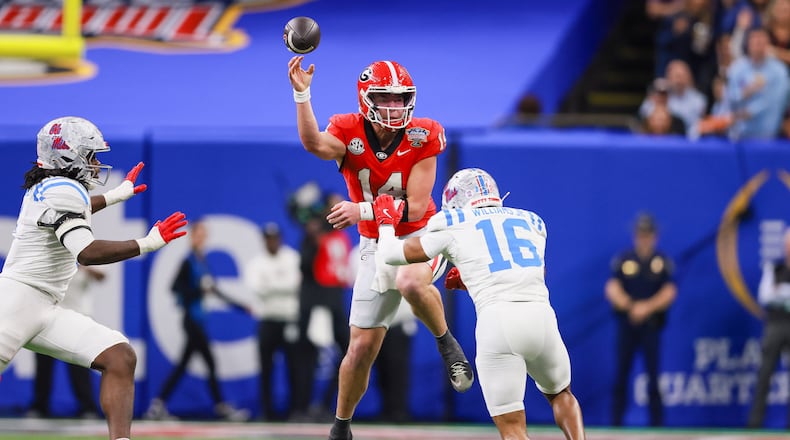 Georgia quarterback Gunner Stockton (center) faces pressure from Ole Miss safety Wydett Williams Jr. (right) during the Sugar Bowl at the Caesars Superdome on Thursday, Jan. 1, 2026, in New Orleans. The Rebels beat the Bulldogs, 39-34. (Jason Getz/AJC)