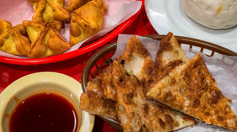 Crab rangoon, a sweet steamed bun and a scallion pancake all served as impressive supporting players at Dumpling Factory. (Henri Hollis/AJC)