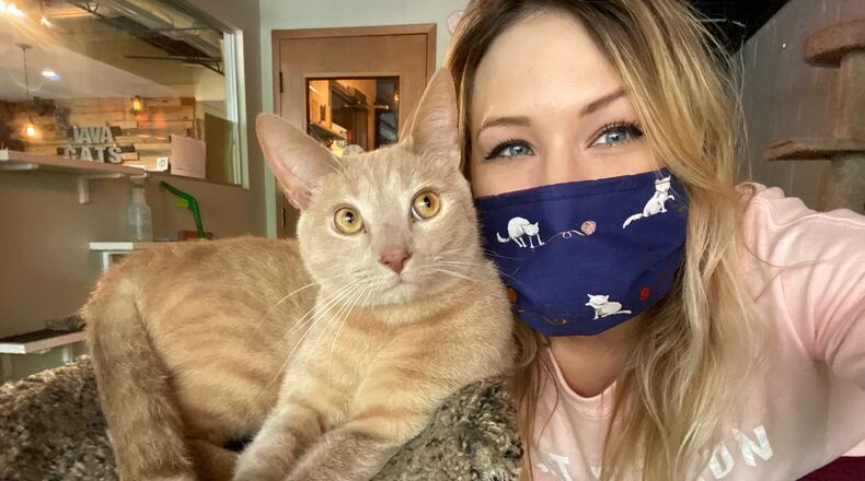 Hadyn Hilton, owner of Java Cats, with her buddy KB, who has since been adopted.