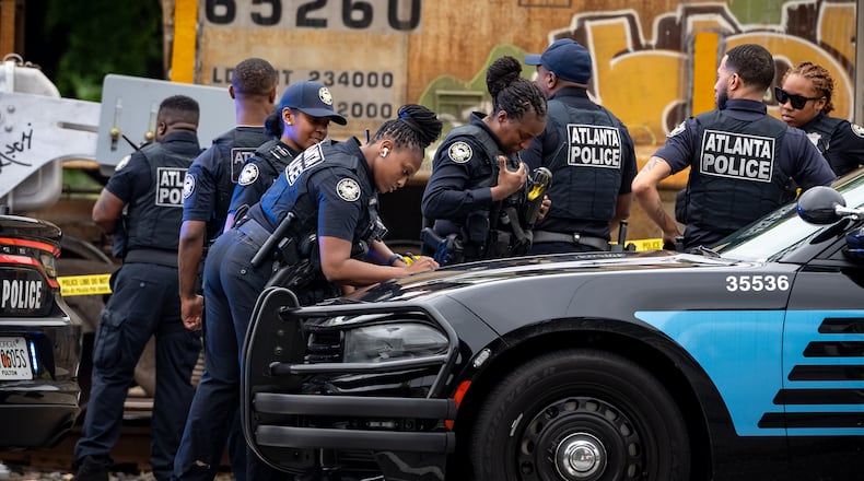 Atlanta police are seen assisting Norfolk Southern police after a woman was killed by a train in southwest Atlanta on Monday.