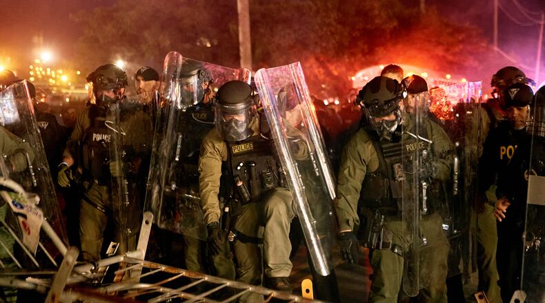 Police pass over a barricade as they clash with protesters near the Delaney Hall detention center during a protest against the transfer of detainees and federal immigration policies on Saturday, May 30, 2026, in Newark, N.J. (AP Photo/Andres Kudacki)