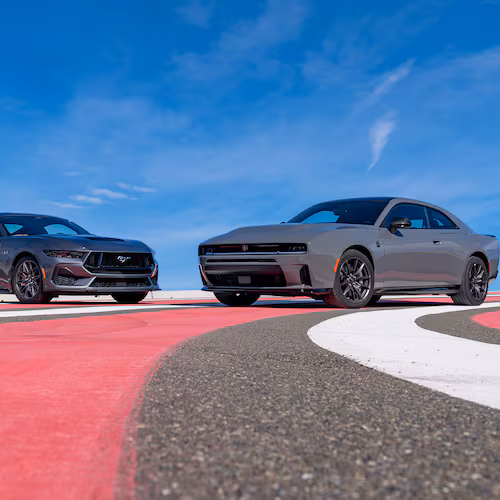 This photo provided by Edmunds shows the newest Dodge Charger and Ford Mustang, historic rivals. (Courtesy of Edmunds via AP)